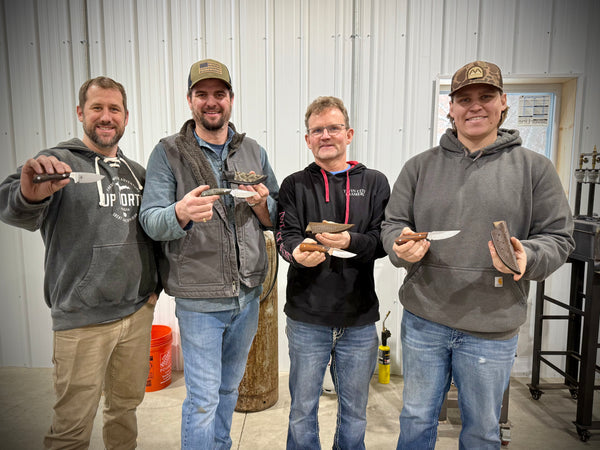 Handcrafted hunter knives being held after bladesmithing class at Heritage Designs