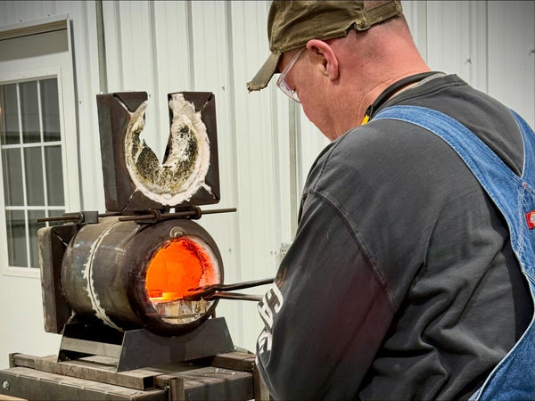 Beginner blacksmith learning hammer techniques at Heritage Designs forge in Minnesota